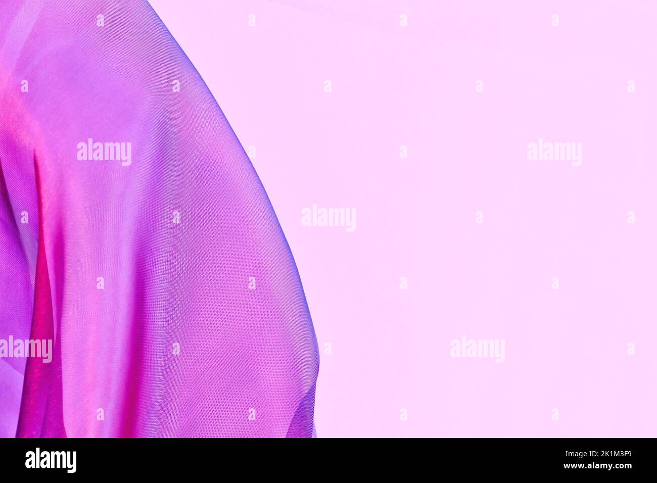 Rete in tulle rosa con tonalità blu sul lato dello sfondo rosa con spazio copia Foto Stock
