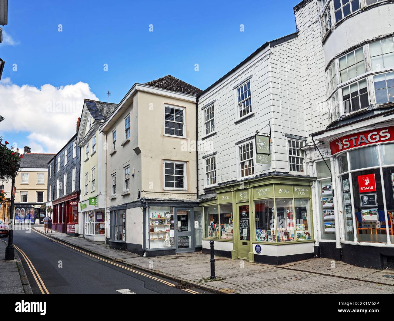 Una libreria indipendente, un negozio di wholefoood accanto a Oxfam e agenti immobiliari nella città di Tavistock, nella parte occidentale del Devon Foto Stock