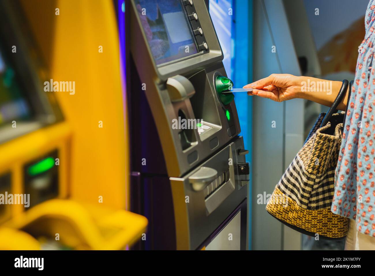 Mano donna inserire una carta di credito in un bancomat. Foto Stock