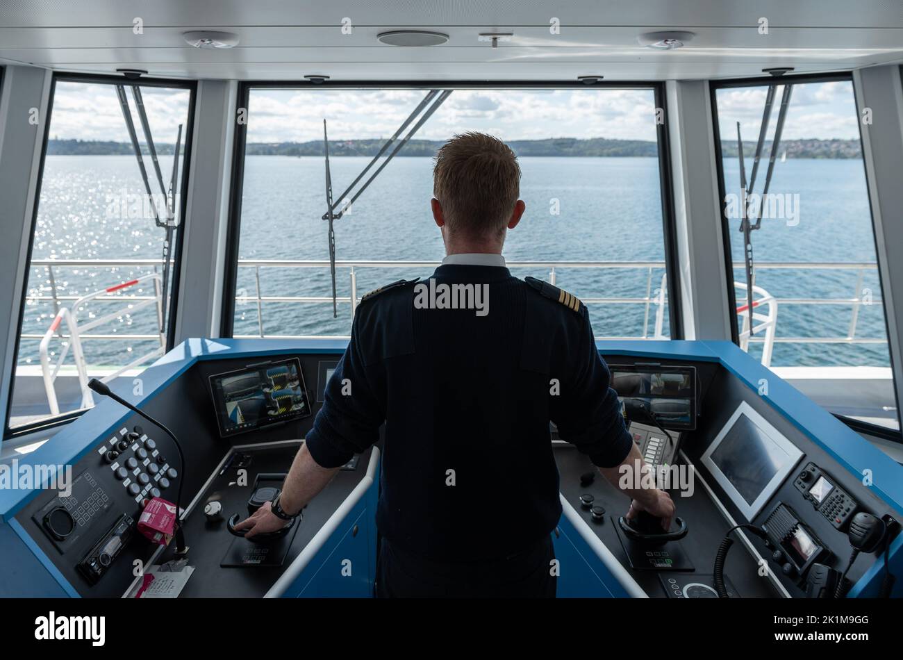 Unteruhldingen, Germania. 19th Set, 2022. Armatore Jürgen Marin sul ponte del traghetto elettrico a batteria gestito da Bodensee-Schiffsbetriebe (BSB). La nave, che prende il nome dall'isola di Mainau, è destinata a ospitare fino a 300 persone in ciascuna delle sue escursioni verso l'isola dei fiori e la riva settentrionale del lago. A questo scopo, il traghetto, che costa 3,6 milioni di euro, ha una batteria da 1.000 kilowatt-ora che viene ricaricata durante la pausa pranzo e di notte. Per risparmiare energia, la nave viaggia a 15 chilometri all'ora in acqua. Credit: Silas Stein/dpa/Alamy Live News Foto Stock