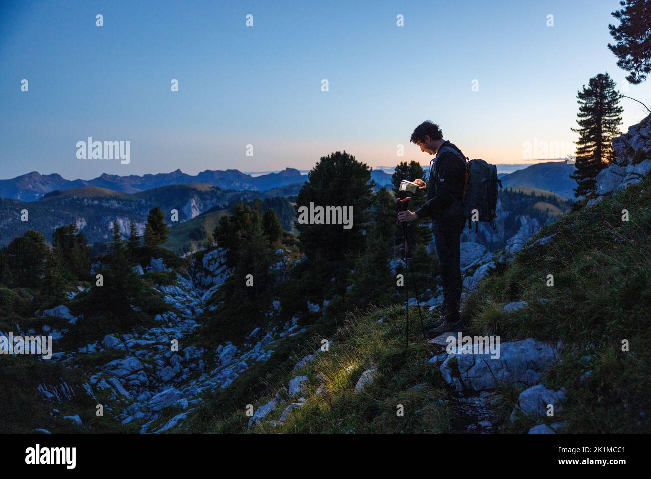 Silhouette di escursionista con faro al crepuscolo in Naturpark Diemtigtal Foto Stock