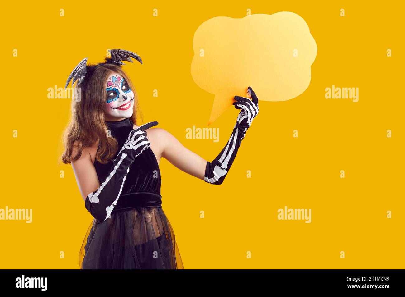 Bambino in costume di Halloween pubblicità evento festivo e mostrando giallo mockup bolla di discorso Foto Stock