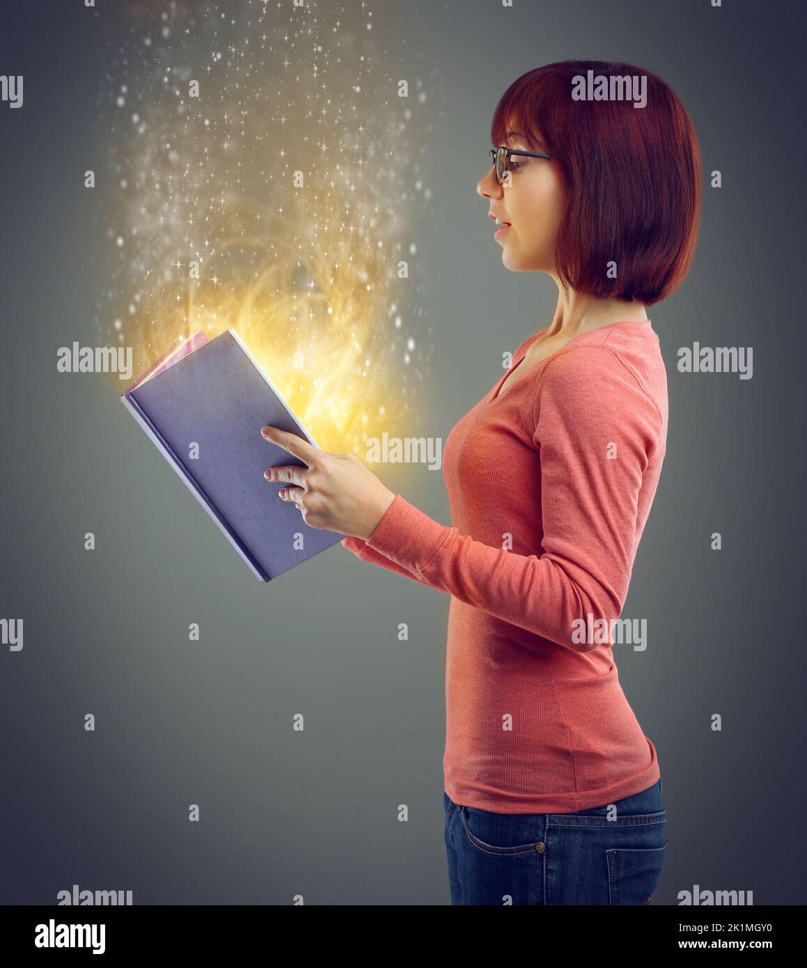 Trovare nuovi mondi magici da esplorare. Un'immagine ritagliata di un giovane adulto che legge un libro con pagine incandescenti. Foto Stock