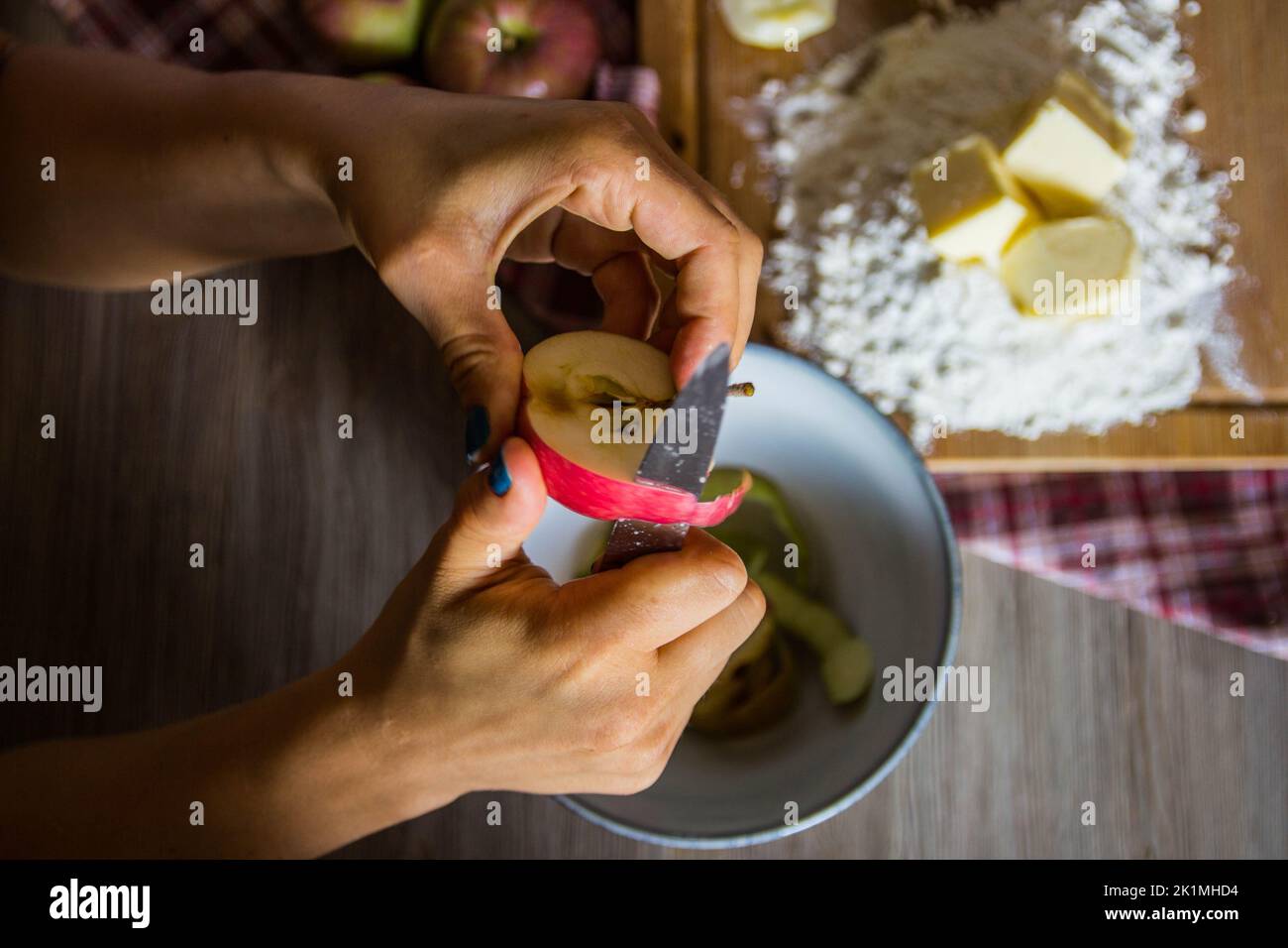 Le mani di una donna che sbuccia una mela per una torta Foto Stock