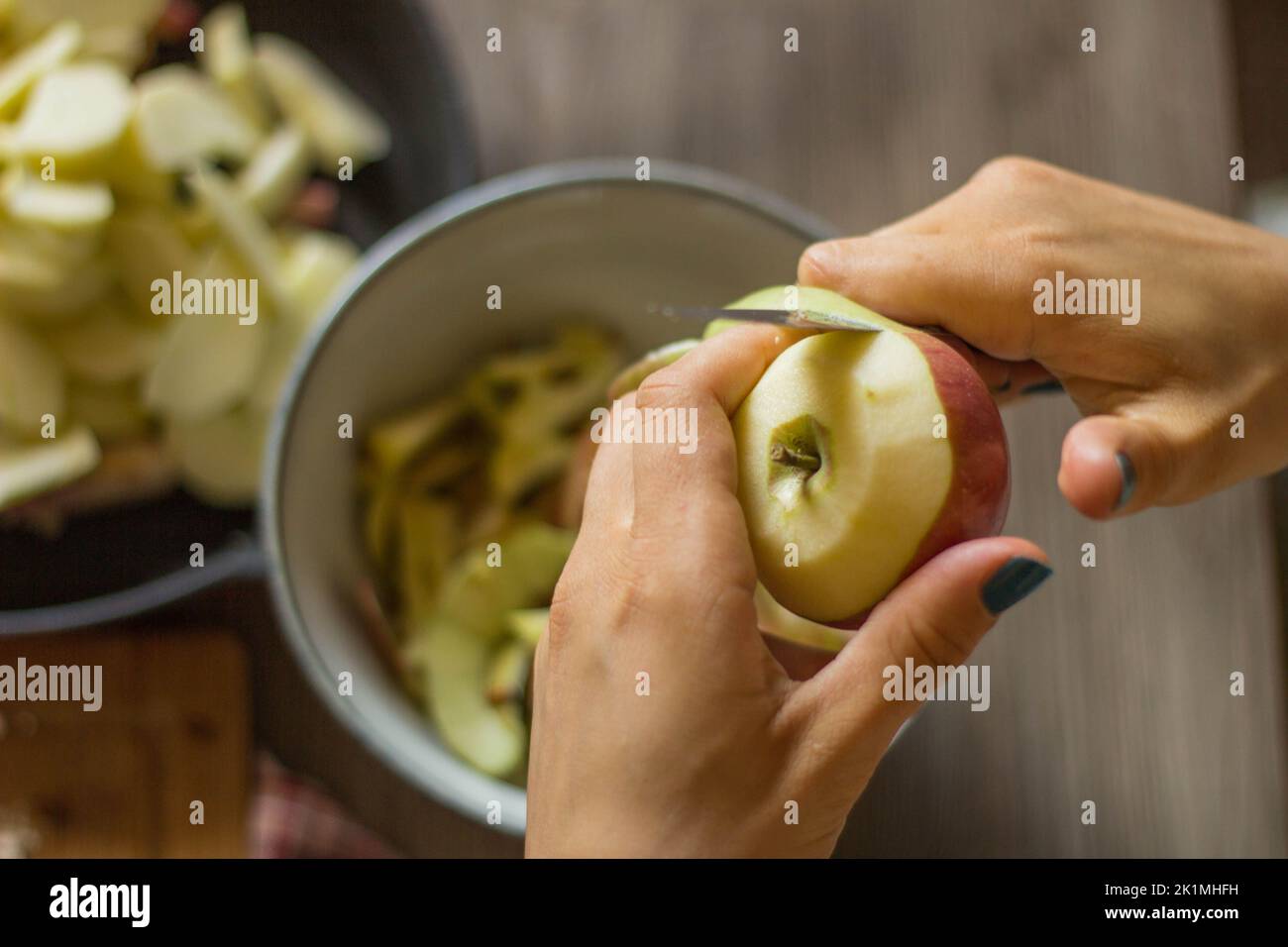 Le mani di una donna che sbuccia un applico per una torta Foto Stock