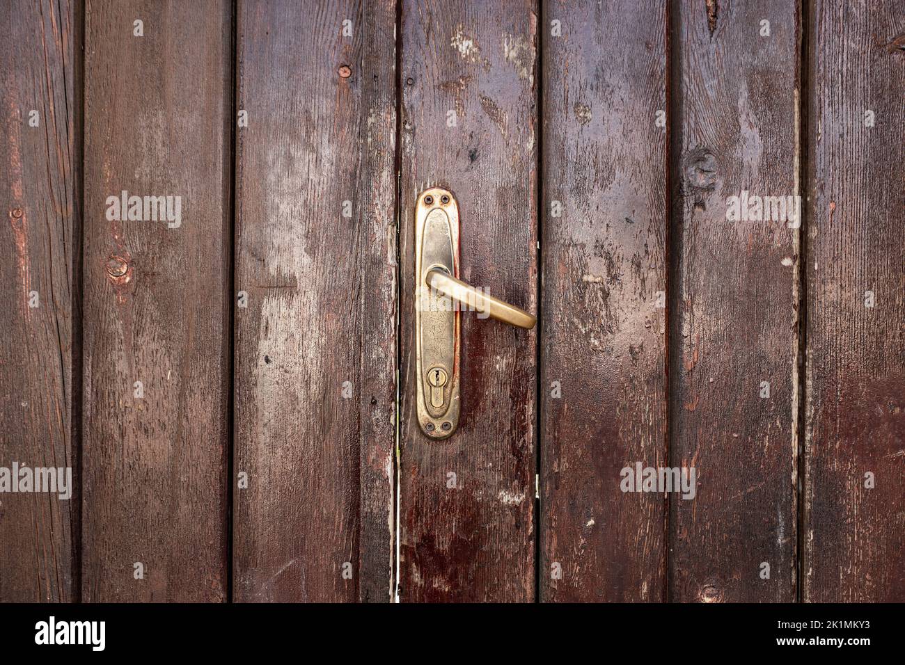 Vecchio, classico sbiadito, marrone, porta in legno con maniglia in ferro. Texture e sfondo delle porte. Foto di alta qualità Foto Stock