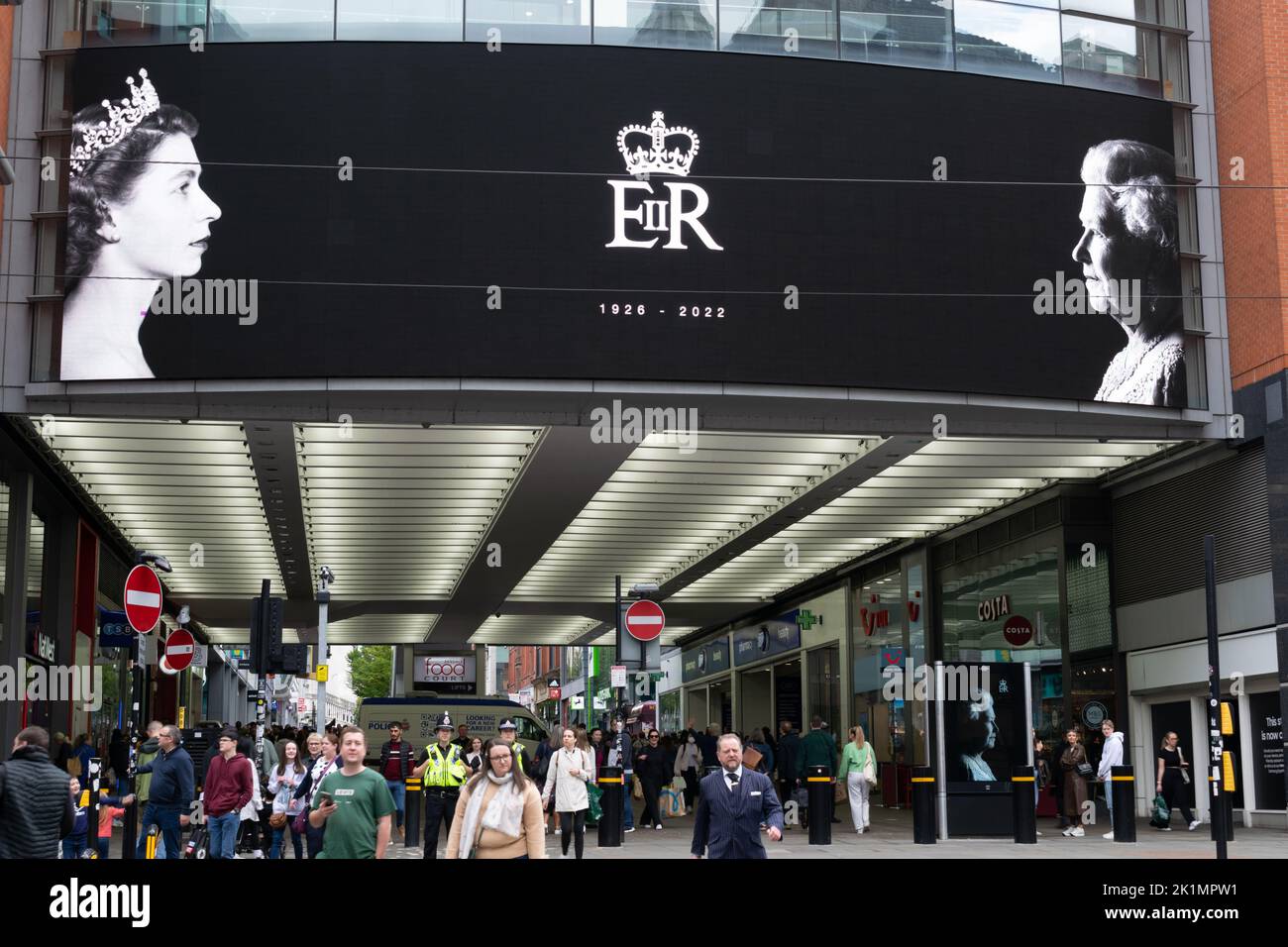 Market Street Manchester. Display elettronico che mostra la giovane e vecchia regina Elisabetta II Vigilia di funerale del monarca. Foto Stock