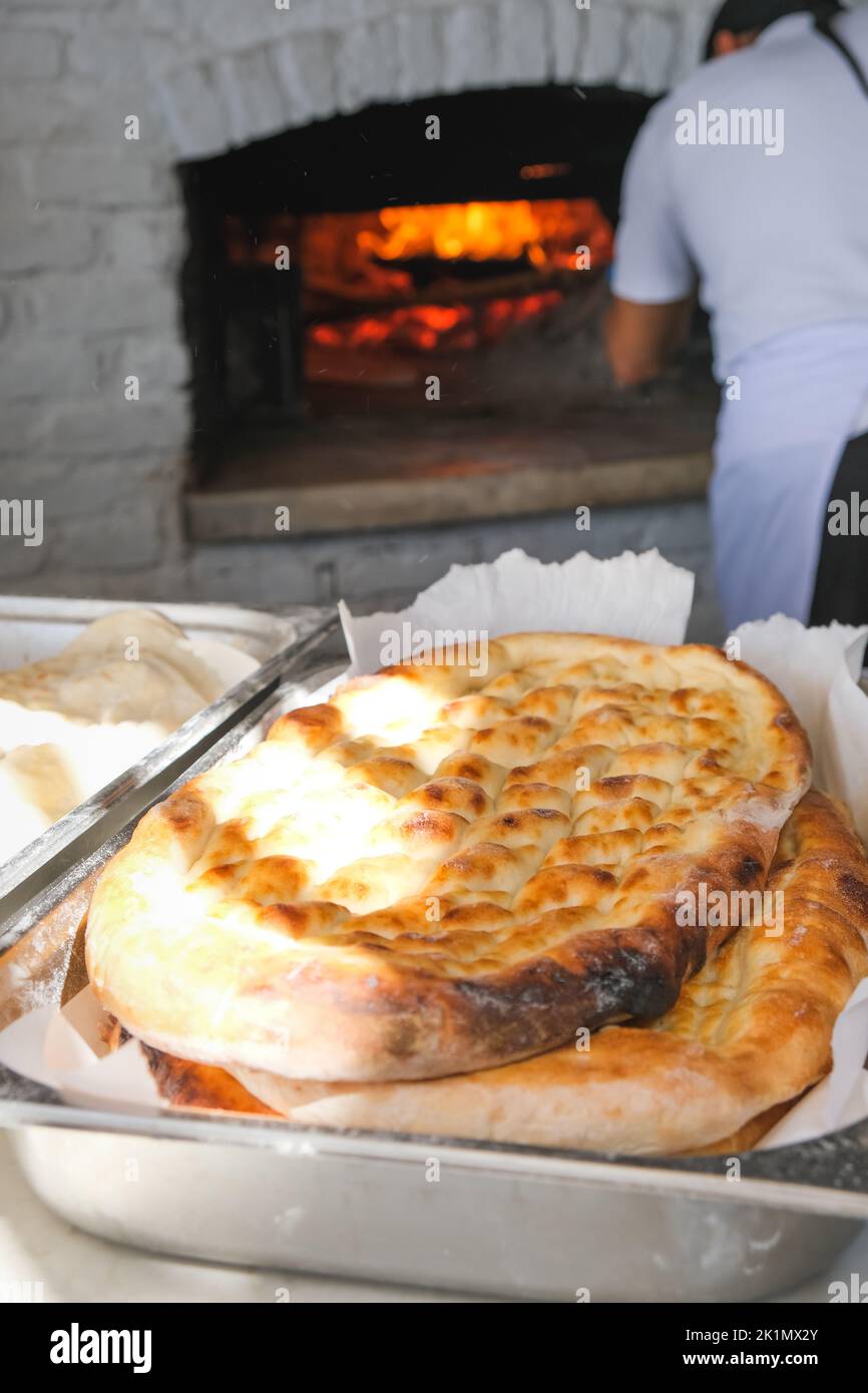 Pane tradizionale in una panetteria turca durante il periodo Ramadan - Ramazan pidesi, in un forno di pietra, immagine verticale. Foto Stock