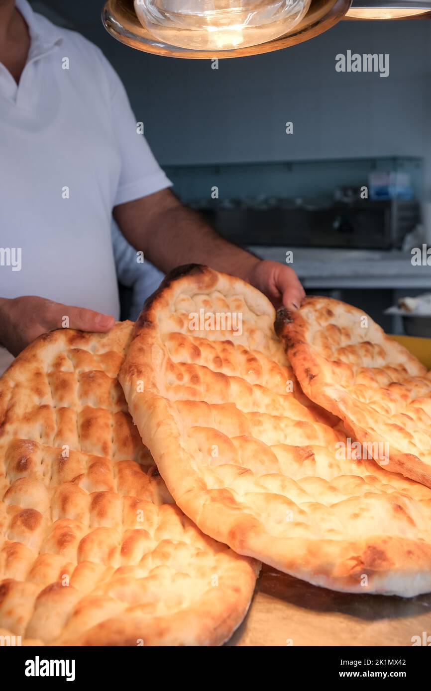Pane tradizionale in una panetteria turca durante il periodo Ramadan - Ramazan pidesi, in un forno di pietra, immagine verticale. Foto Stock