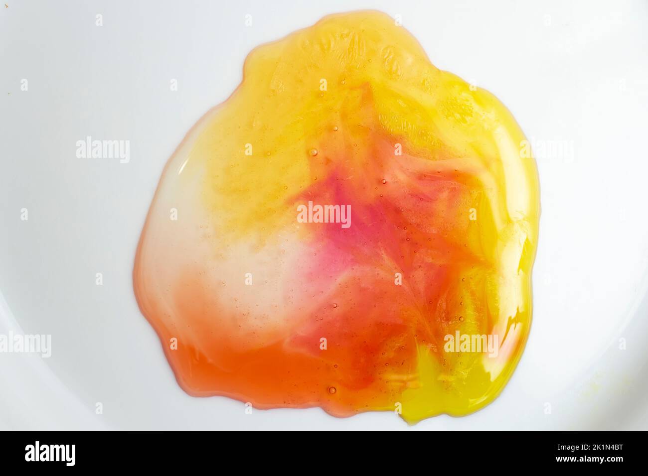 Orsi di gelatina multicolore fusi, su sfondo bianco. Primo piano con messa a fuoco morbida. Foto Stock