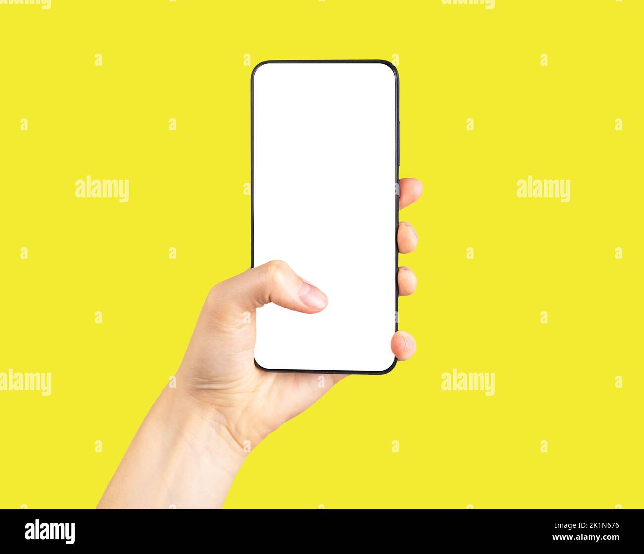 Tenere il telefono mockup e fare clic o scorrere su sfondo giallo. Donna che utilizza lo smartphone per navigare su Internet e sui social media. Modello telefono Foto Stock