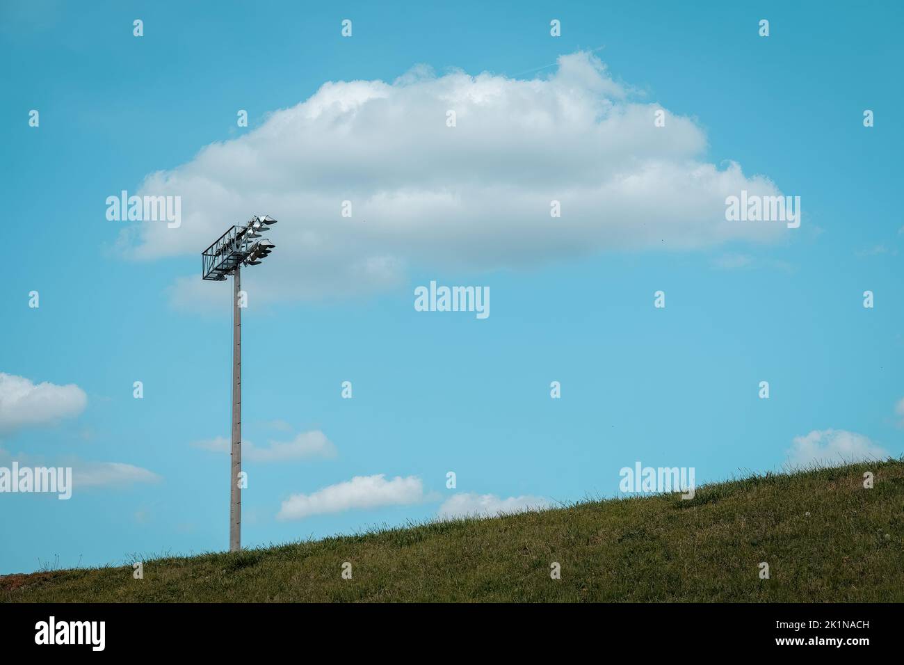 Singola arena verde chiaro collina e soffici nuvole bianche. Foto Stock