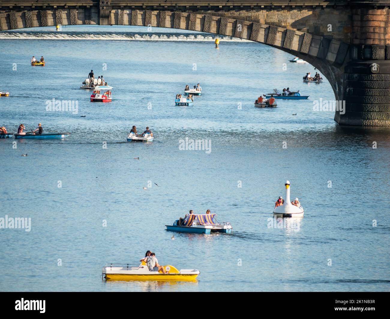 Praga, Repubblica Ceca - Giugno 2022: Molti turisti e locali in piccole barche sul fiume Moldava godendo di una vacanza o di un giorno di fine settimana Foto Stock