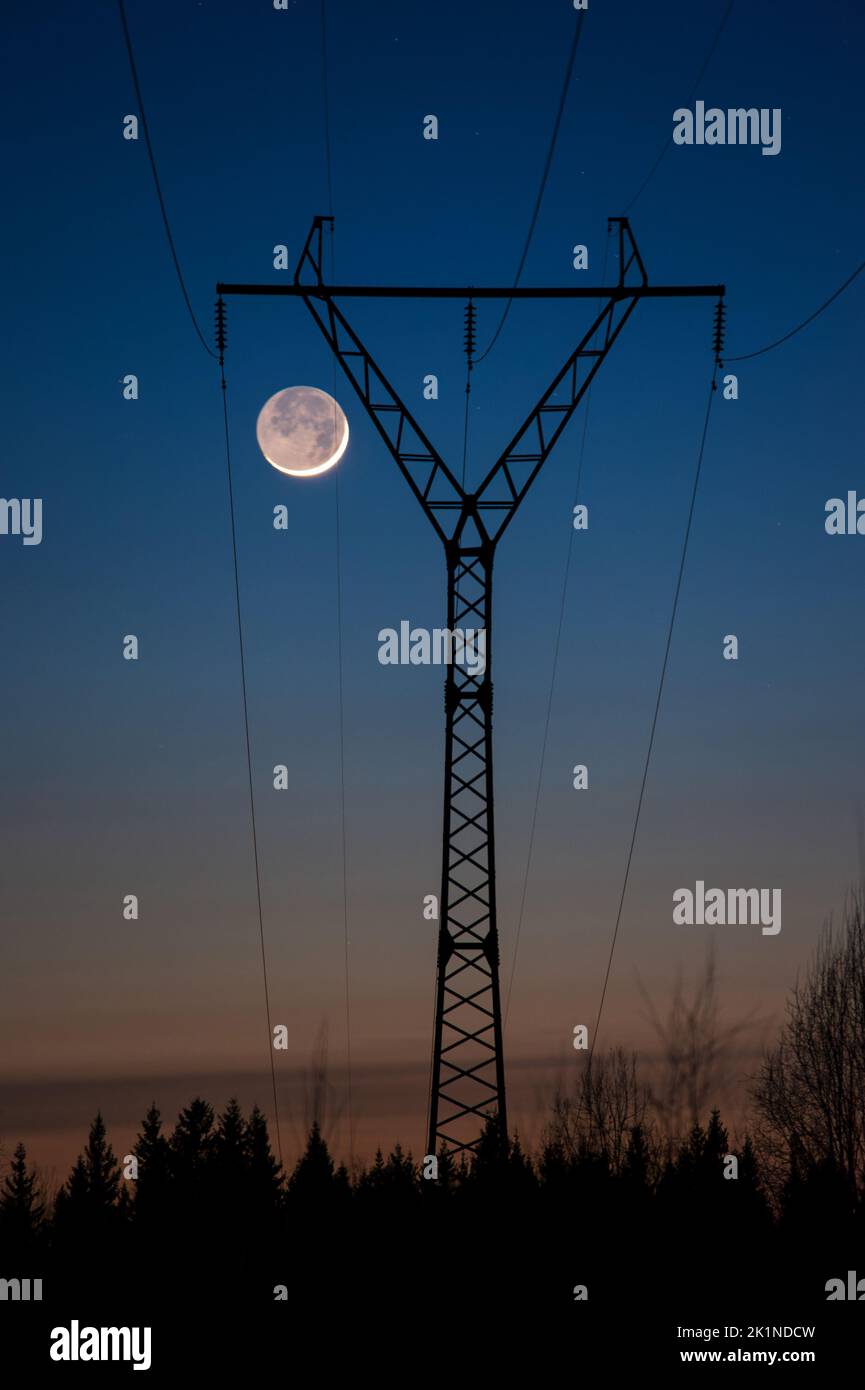 Paesaggio serale con linea elettrica ad alta tensione, Luna crescente in cielo oscuro. Foto Stock Paesaggio serale con linea elettrica ad alta tensione, Luna crescente in cielo oscuro. Foto Stock