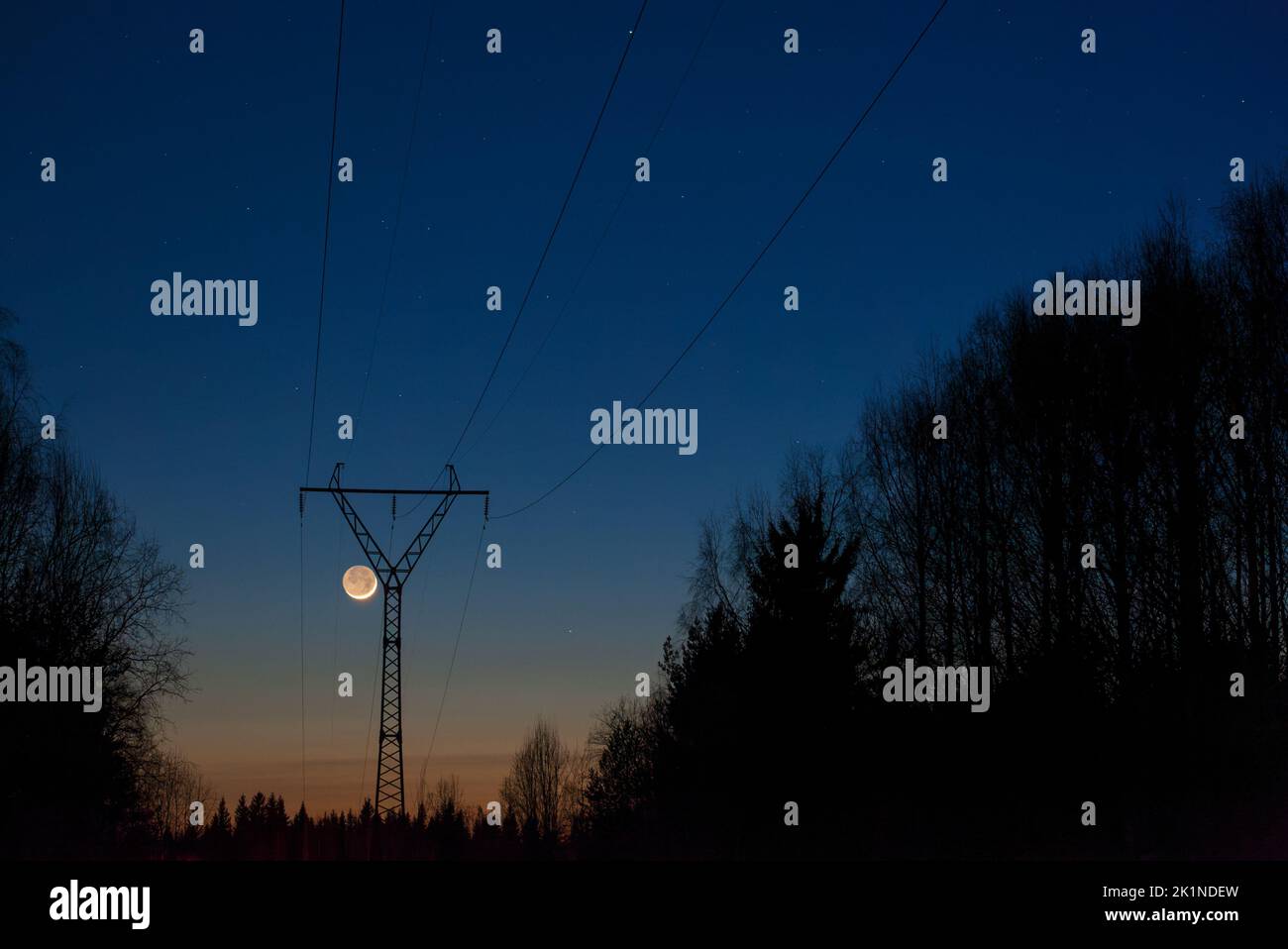 Paesaggio serale con linea elettrica ad alta tensione, Luna crescente in cielo oscuro. Foto Stock Paesaggio serale con linea elettrica ad alta tensione, Luna crescente in cielo oscuro. Foto Stock