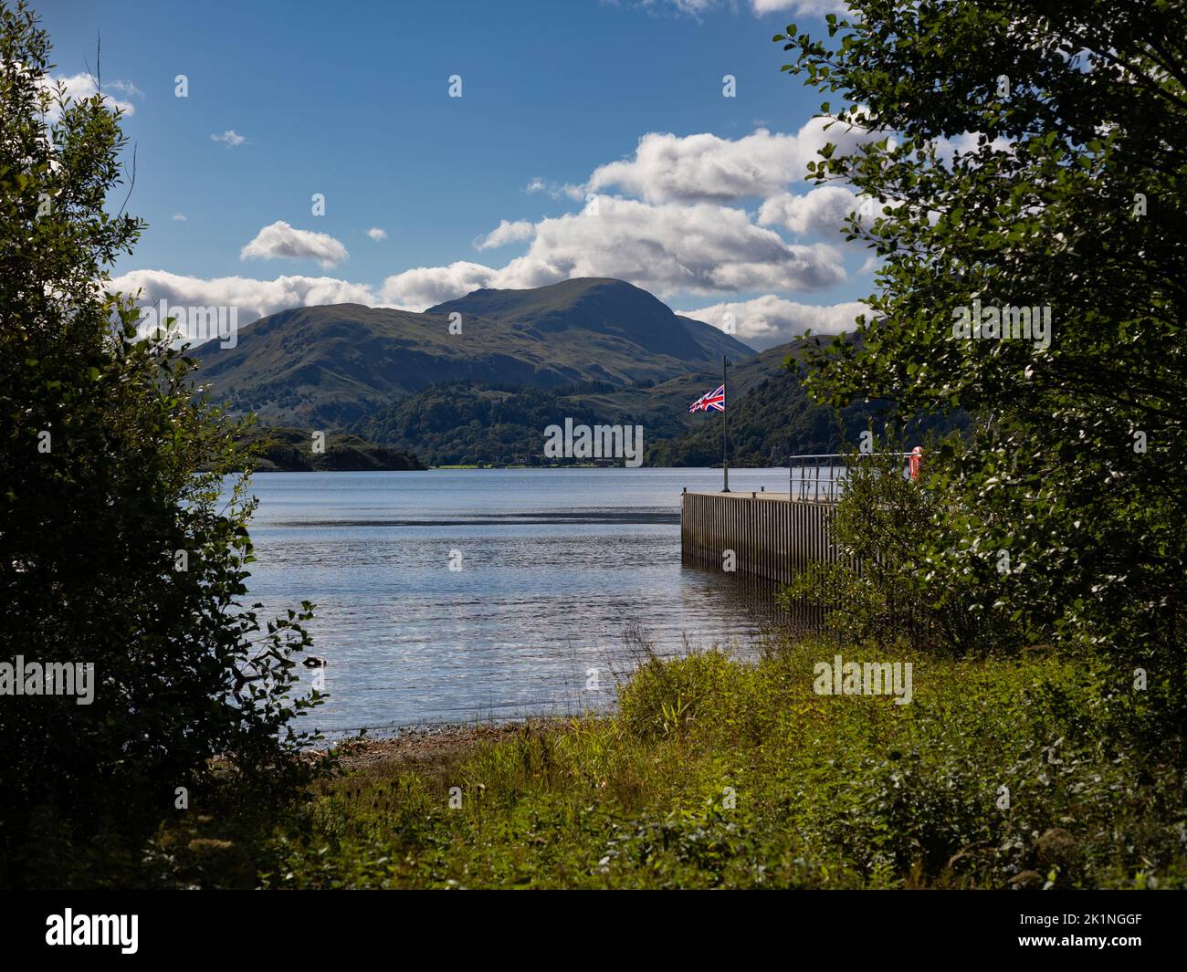 Union Flag è volata a metà albero su un molo a Ullswater, Lake District Cumbria.UK. La bandiera è a metà albero a causa del passaggio della Regina. Foto Stock