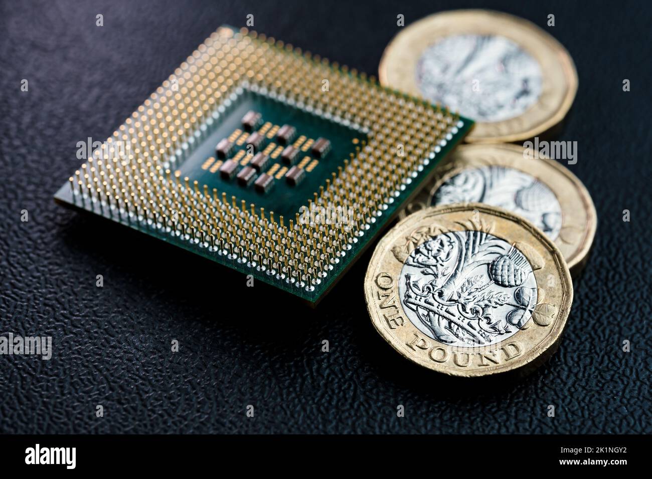 CPU con chip per computer di grandi dimensioni e monete da sterline britanniche. Concetto per microchip e denaro. Macro, messa a fuoco selettiva. Foto Stock