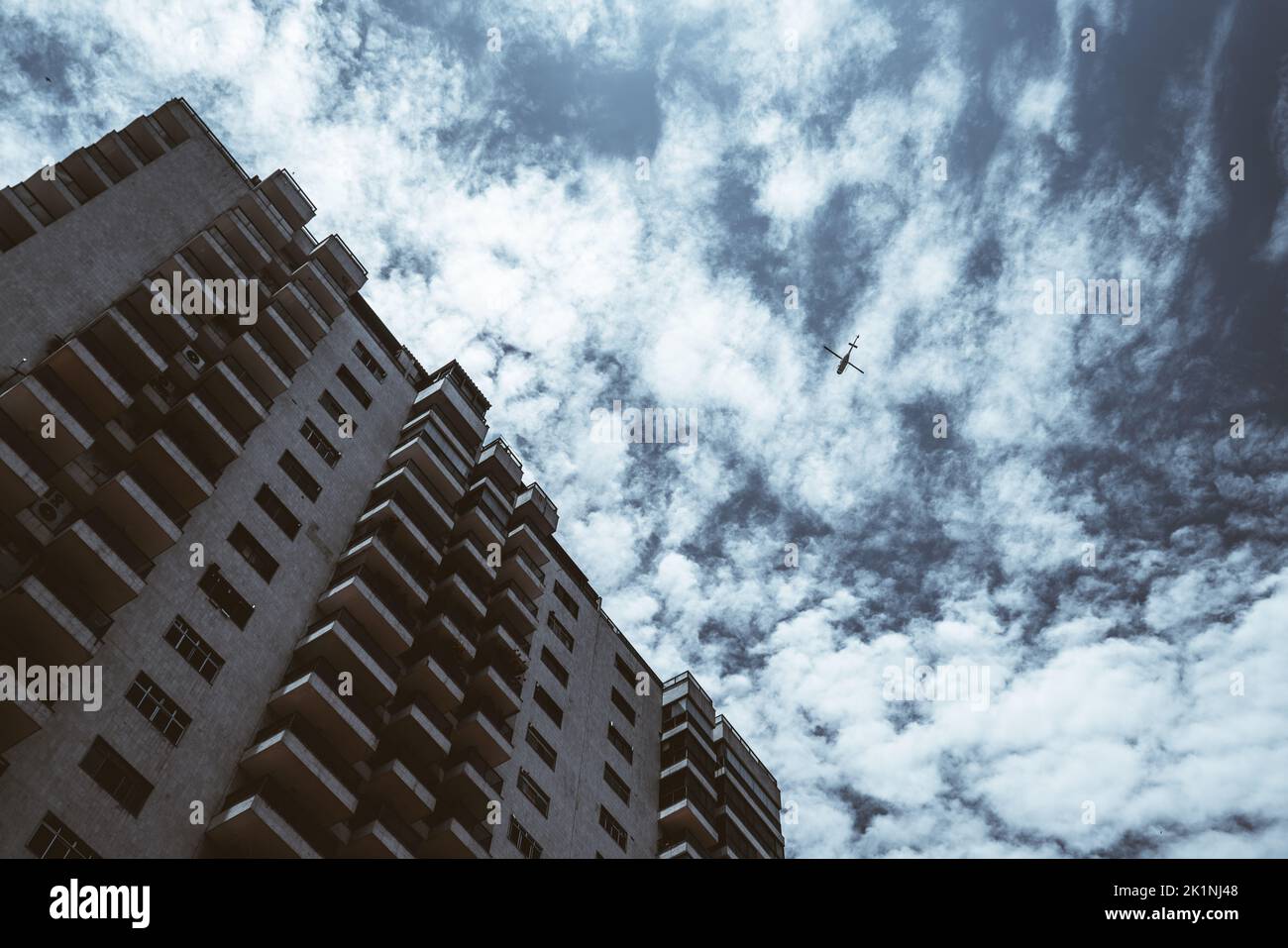 Vista dal fondo di una casa residenziale con l'elevazione con abbondanza di balconi e finestre, bella struttura blu cielo con paesaggio nuvoloso, e la silhou Foto Stock