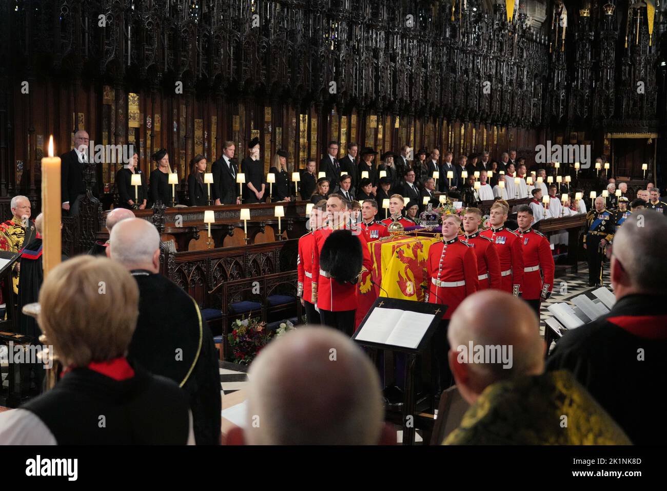 Il clero e i membri della famiglia reale guardano mentre il partito portatore posiziona la bara del tardo monarca sulla catafalque durante il Committal Service per la Regina Elisabetta II tenuto nella Cappella di San Giorgio nel Castello di Windsor, Berkshire. Data immagine: Lunedì 19 settembre 2022. Foto Stock