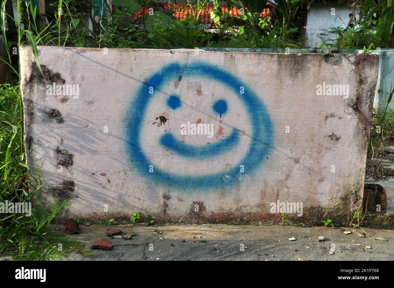 Immagine o illustrazione di un'icona di sorriso blu realizzata con vernice spray sulla parete Foto Stock