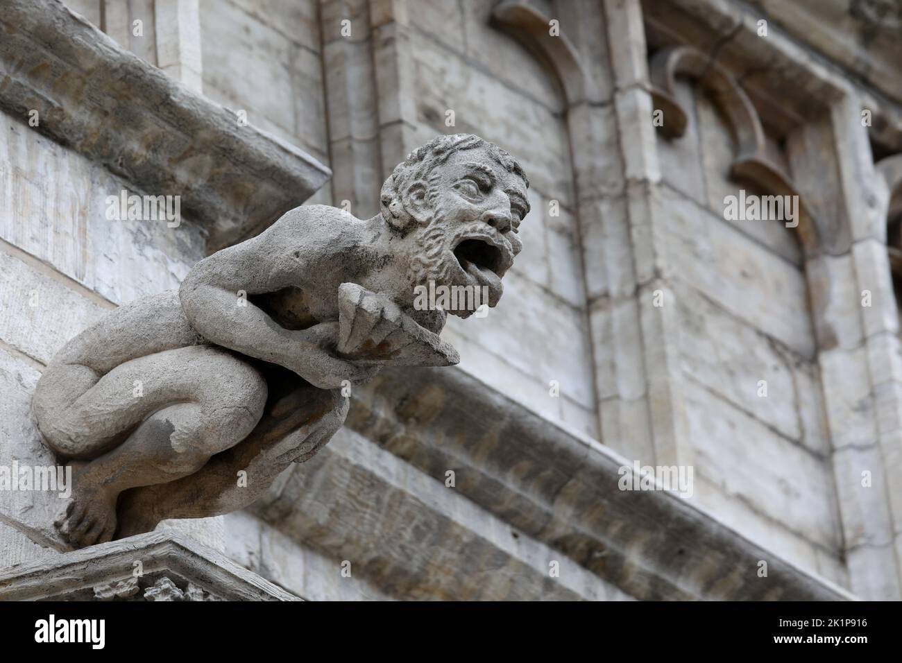 Statua mostruosa con caratteristiche quasi umane chiamato gargoyle sulla facciata dell'edificio storico Foto Stock