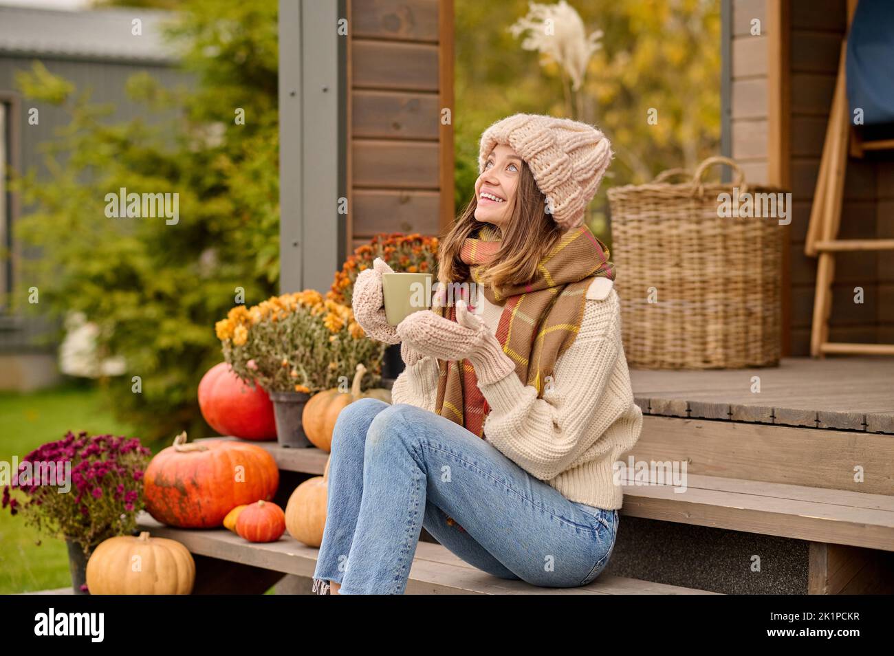 Allegra giovane femmina godendosi la sua pausa caffè sulla veranda Foto Stock