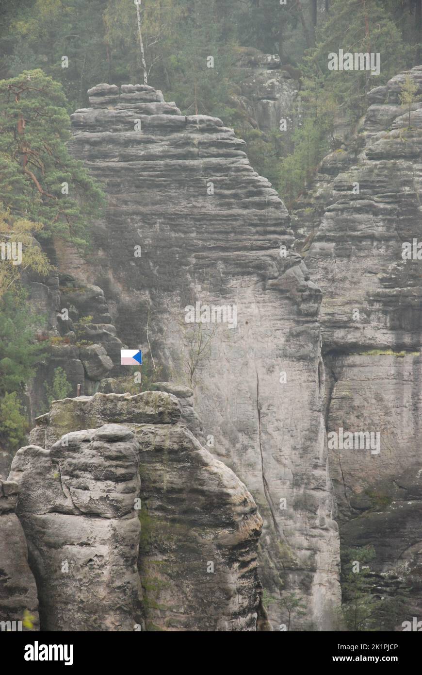 Un colpo verticale di formazioni di arenaria con una bandiera ceca nel Paradiso Boemo in Repubblica Ceca Foto Stock