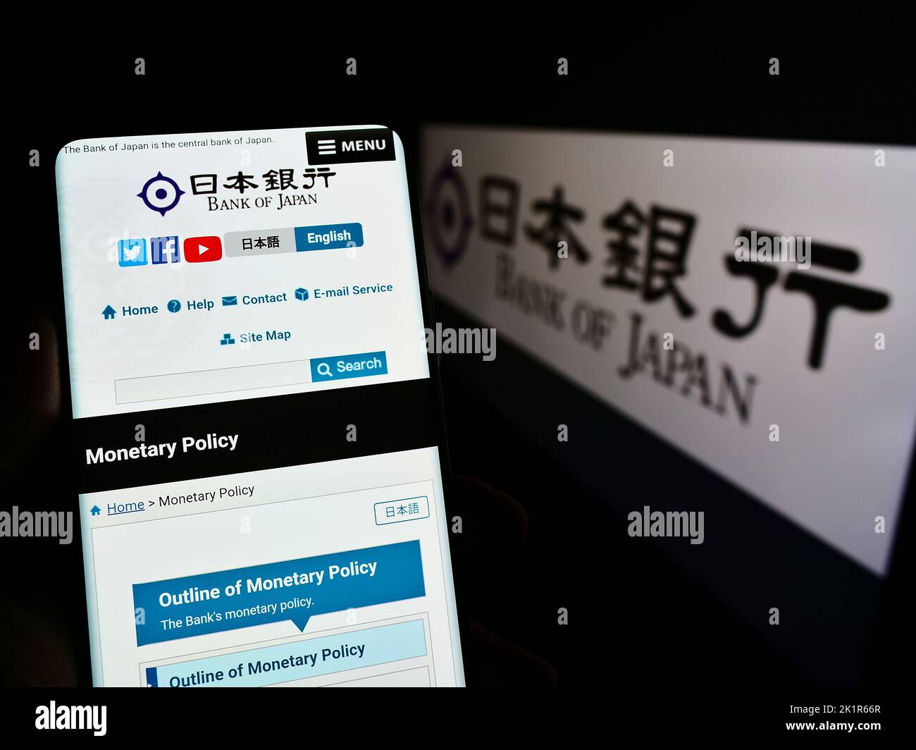 Persona che tiene il telefono cellulare con pagina web dell'istituto finanziario Banca del Giappone (BOJ) sullo schermo con il logo. Messa a fuoco al centro del display del telefono. Foto Stock