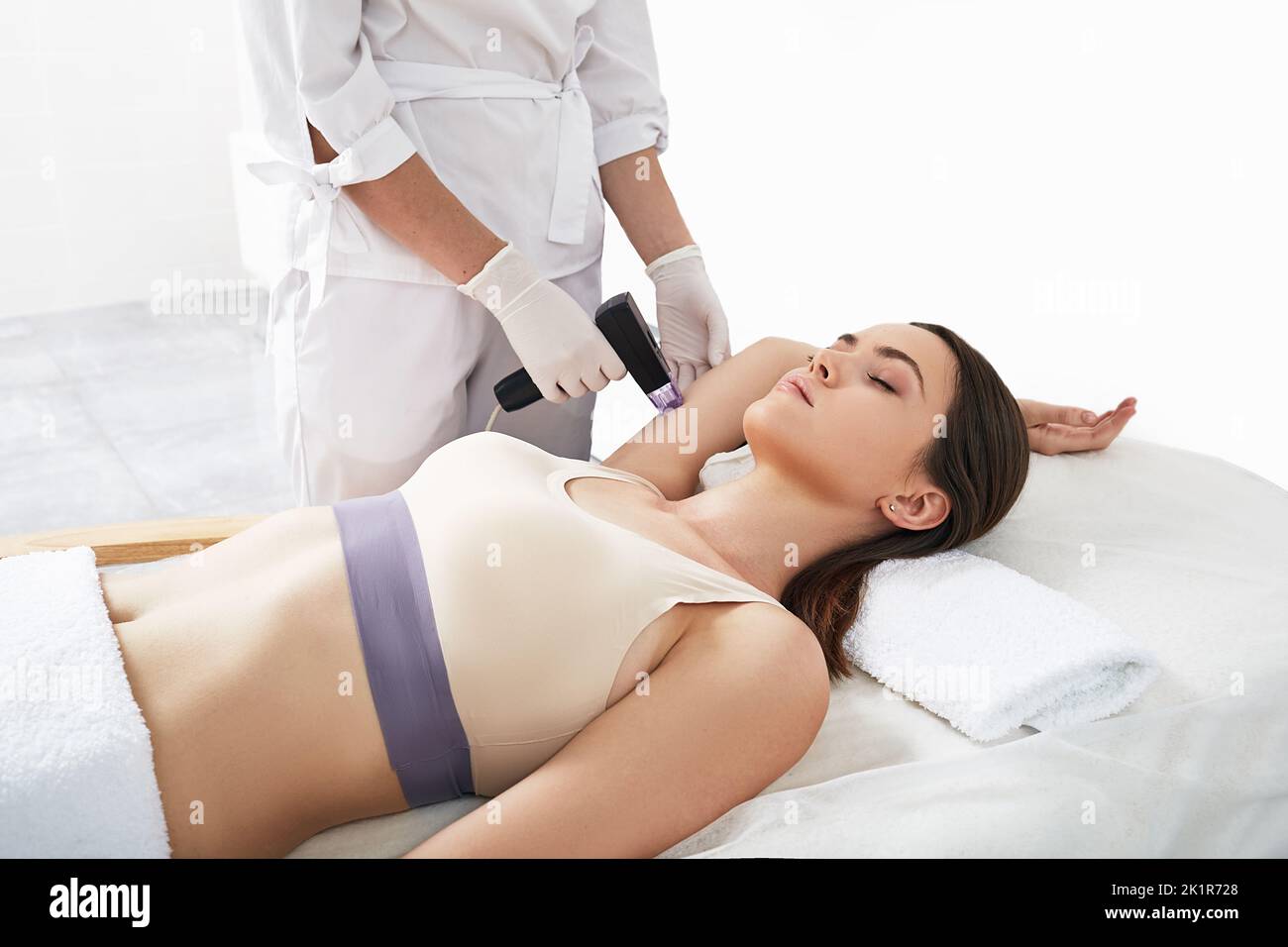 Tecnologia di ringiovanimento laser per pazienti di sesso femminile che utilizza un manipolo cosmetico per il sollevamento della pelle del corpo a radiofrequenza in cosmetologia Foto Stock