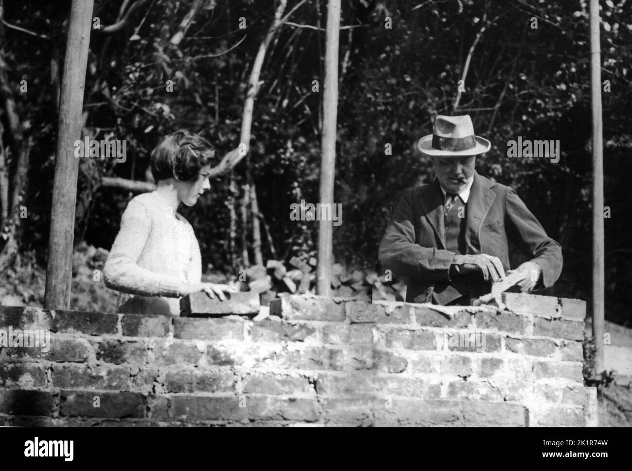 Winston Churchill muratore a Chartwell, assistito da sua figlia, Sarah. 1928 Foto Stock