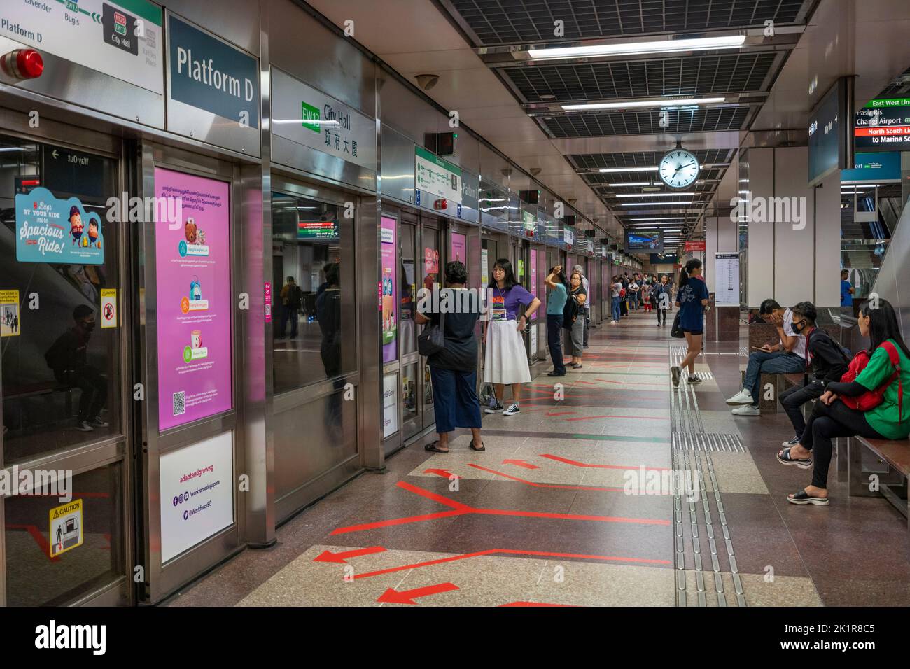 Pendolari in attesa del treno alla stazione di interscambio MRT. Singapore Foto Stock