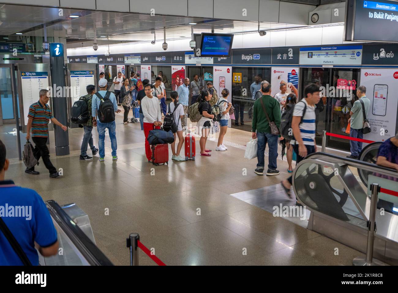 Pendolari in attesa del treno alla stazione di interscambio MRT. Singapore Foto Stock