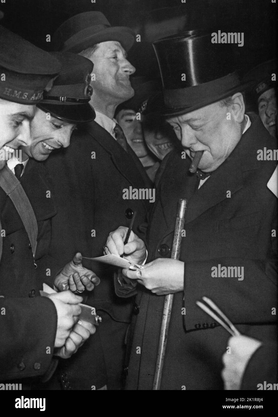 Winston Churchill firmando autografi per due dell'equipaggio di HMS Ajax recentemente tornato dal Sud Atlantico dopo la battaglia del fiume Pate.1940 Foto Stock