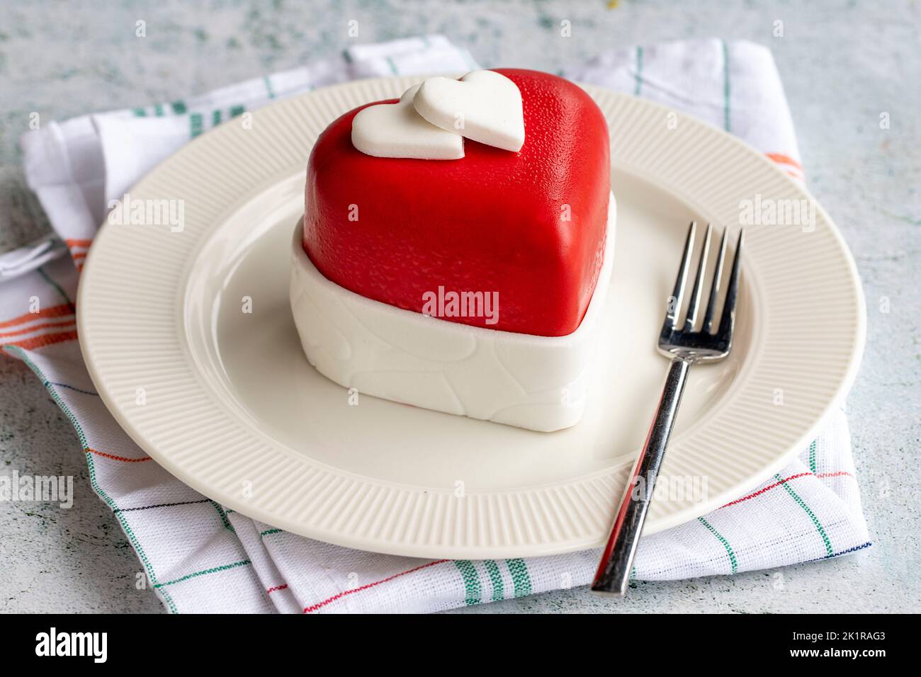 Torta di design speciale a forma di cuore. Disegno torta su sfondo grigio. Primo piano Foto Stock