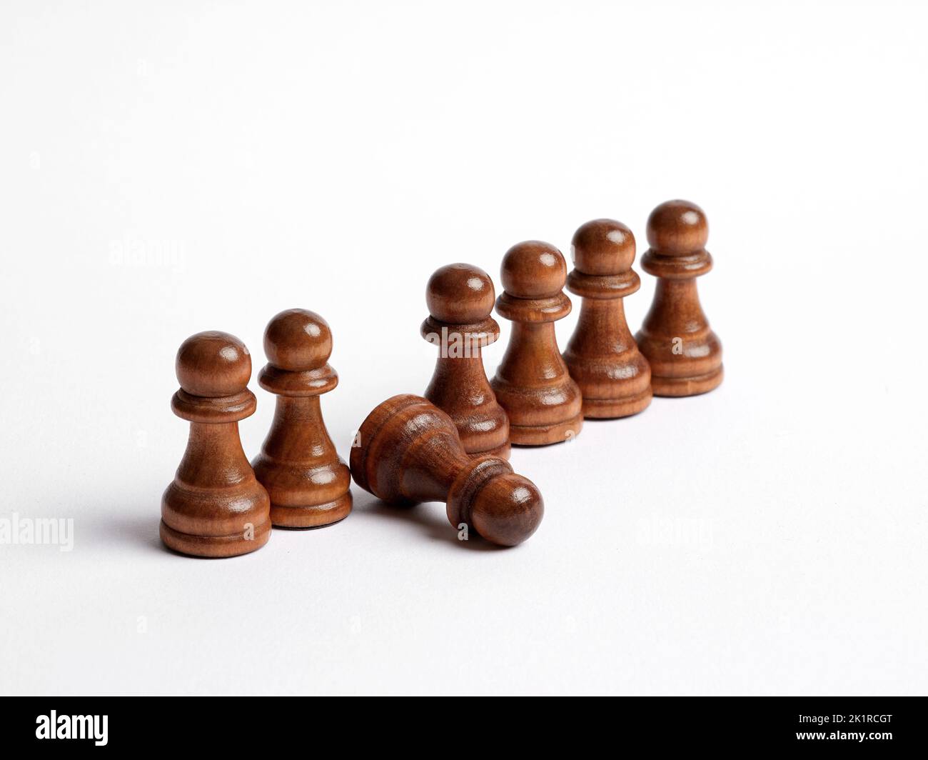 Fila di pedine di scacchi con una pedina cadde in linea. Debole collegamento nel team o nei concetti di esaurimento e esaurimento dei dipendenti. Foto Stock