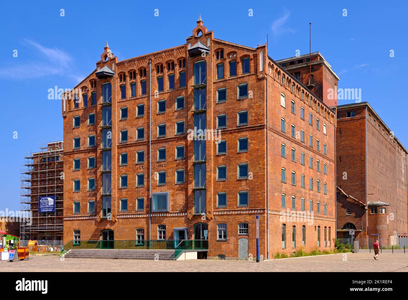 Scena quotidiana e turistica e paesaggio urbano nel Vecchio Porto, di fronte a uno storico edificio magazzino, Wismar, Germania. Foto Stock