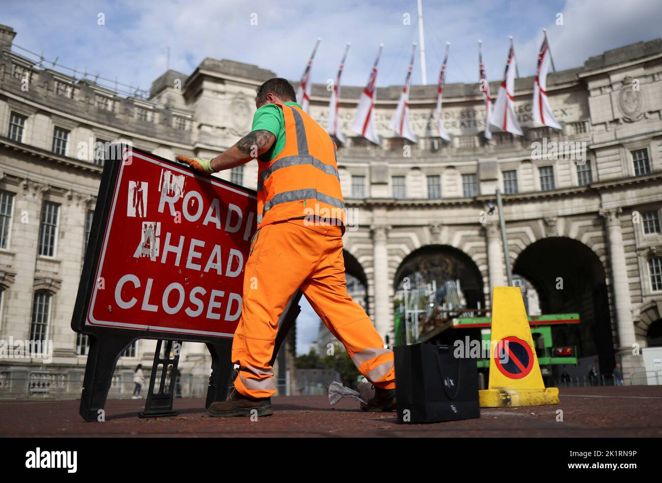 Un uomo muove un cartello stradale, in seguito al funerale della regina Elisabetta britannica, a Londra, Gran Bretagna 20 settembre 2022. REUTERS/Tom Nicholson Foto Stock