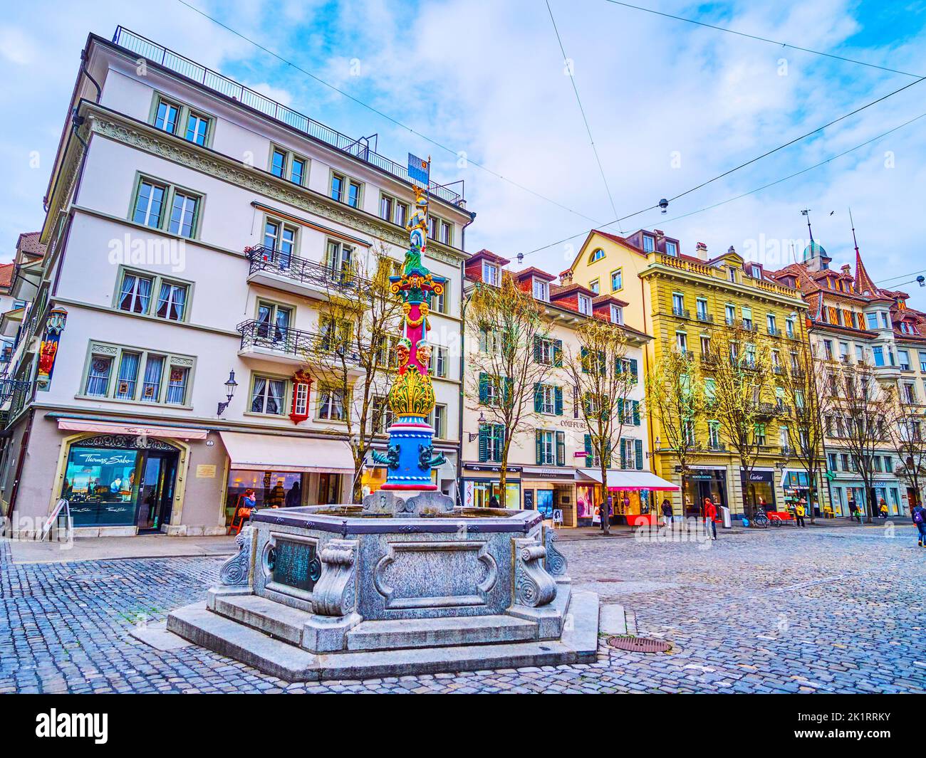 LUCERNA, SVIZZERA - 30 MARZO 2022: Il paesaggio urbano di Lucerna con la colorata Fontana Fritschi in primo piano, il 30 marzo a Lucerna, Svizzera Foto Stock