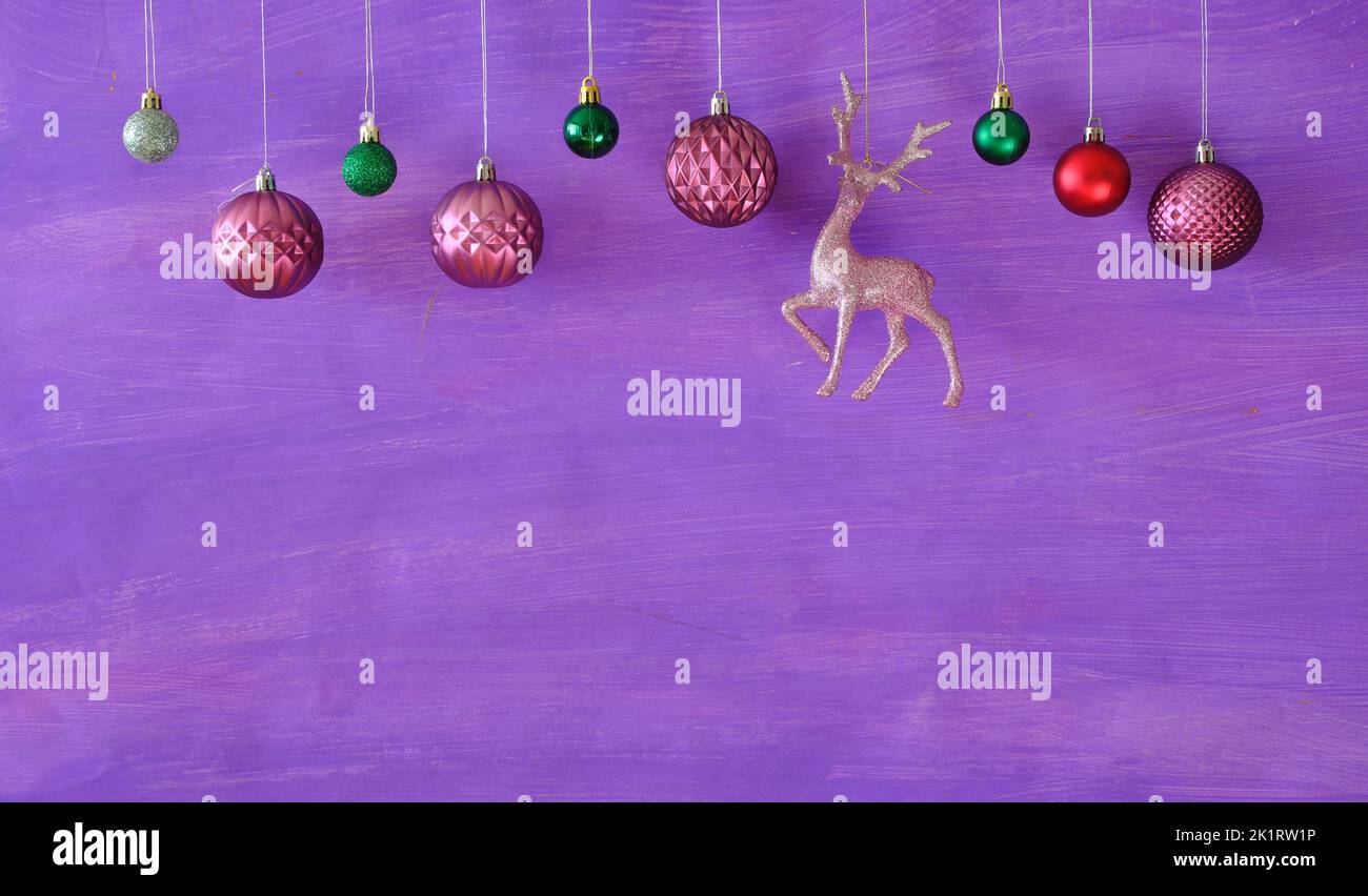 Palle di natale viola appeso su sfondo viola.modello di Natale con grande copia spazio.negativo tecnica spazio. Foto Stock