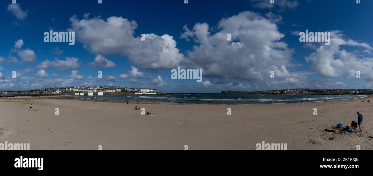 Kilkee, Irlanda - 4 agosto, 2022: La gente gode di una calda giornata estiva sulla spiaggia di sabbia dorata di Kilkee, nell'Irlanda occidentale Foto Stock