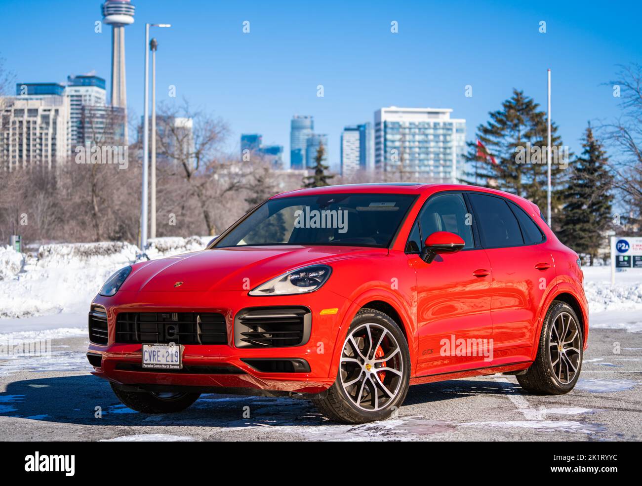 A Red Porsche Cayenne in un parcheggio basso in una giornata di sole durante l'inverno Foto Stock