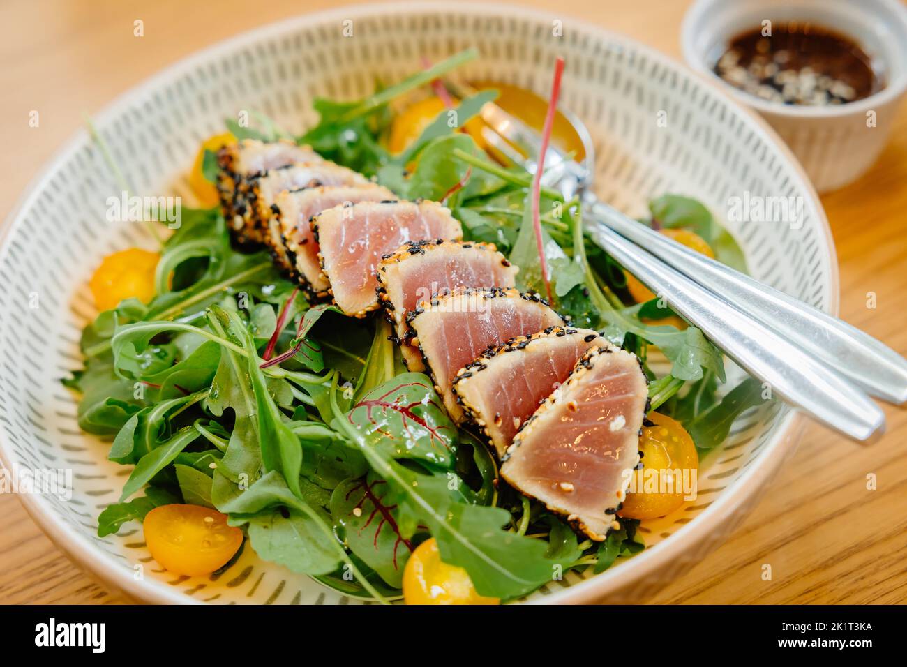 Insalata di tonno condimento sesamo mangiare menu, cibo pulito sano buon pasto proteine e verdure. Foto Stock