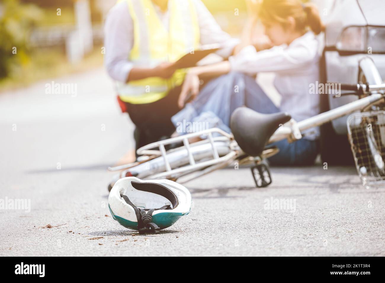 Incidente di bicicletta colpito da auto sulla strada autostrada scena conducente seduto assicurazione personale aiutare sostegno Foto Stock
