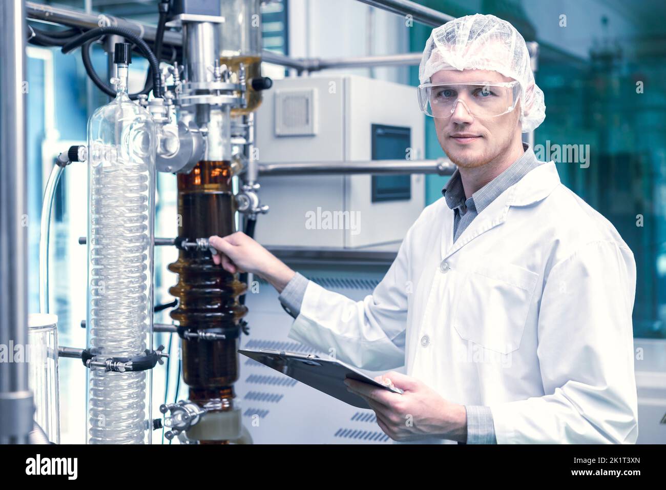 Operatore scientifico della fabbrica di medicina con la macchina per l'estrazione dell'olio CBD Cannabis. Estrazione di olio di canapa distillazione a film sottile processo di laboratorio piante. Foto Stock