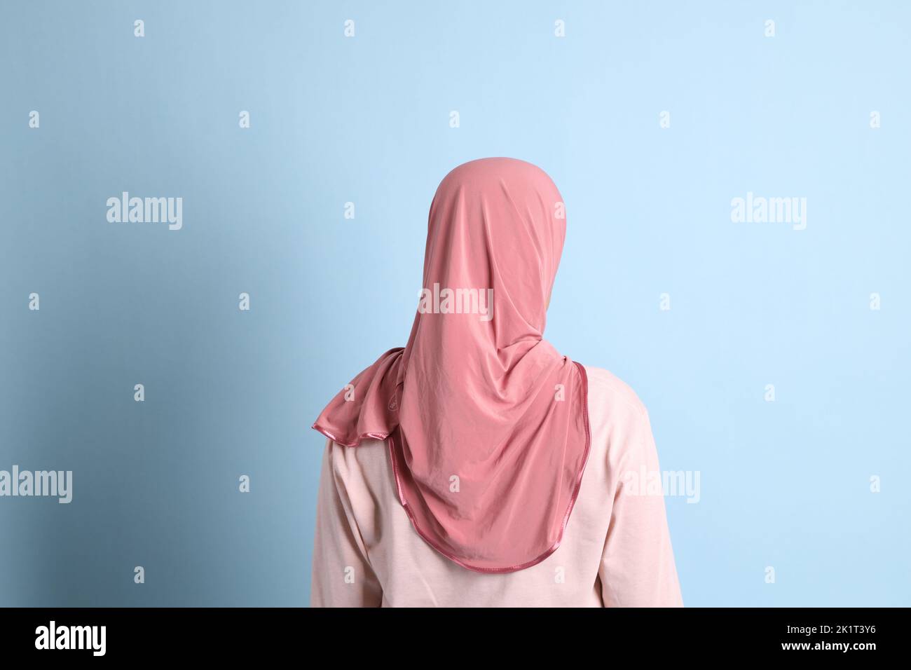 La donna del sud-est asiatico con hijab in piedi sullo sfondo blu Foto Stock