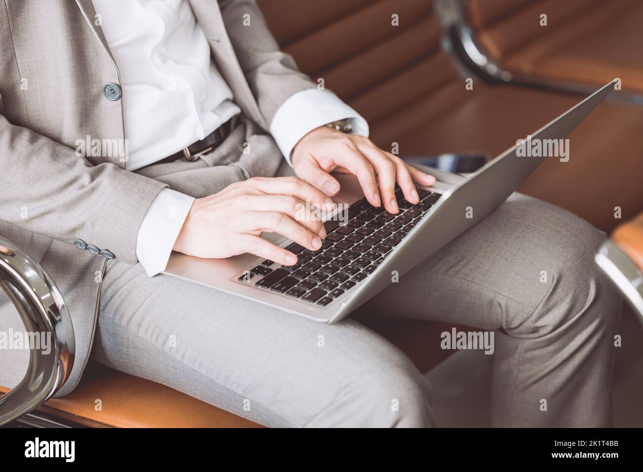 chiudioup businessman scrivere a mano sul computer portatile seduto in banco di attesa lavoro senza fili concetto. Foto Stock
