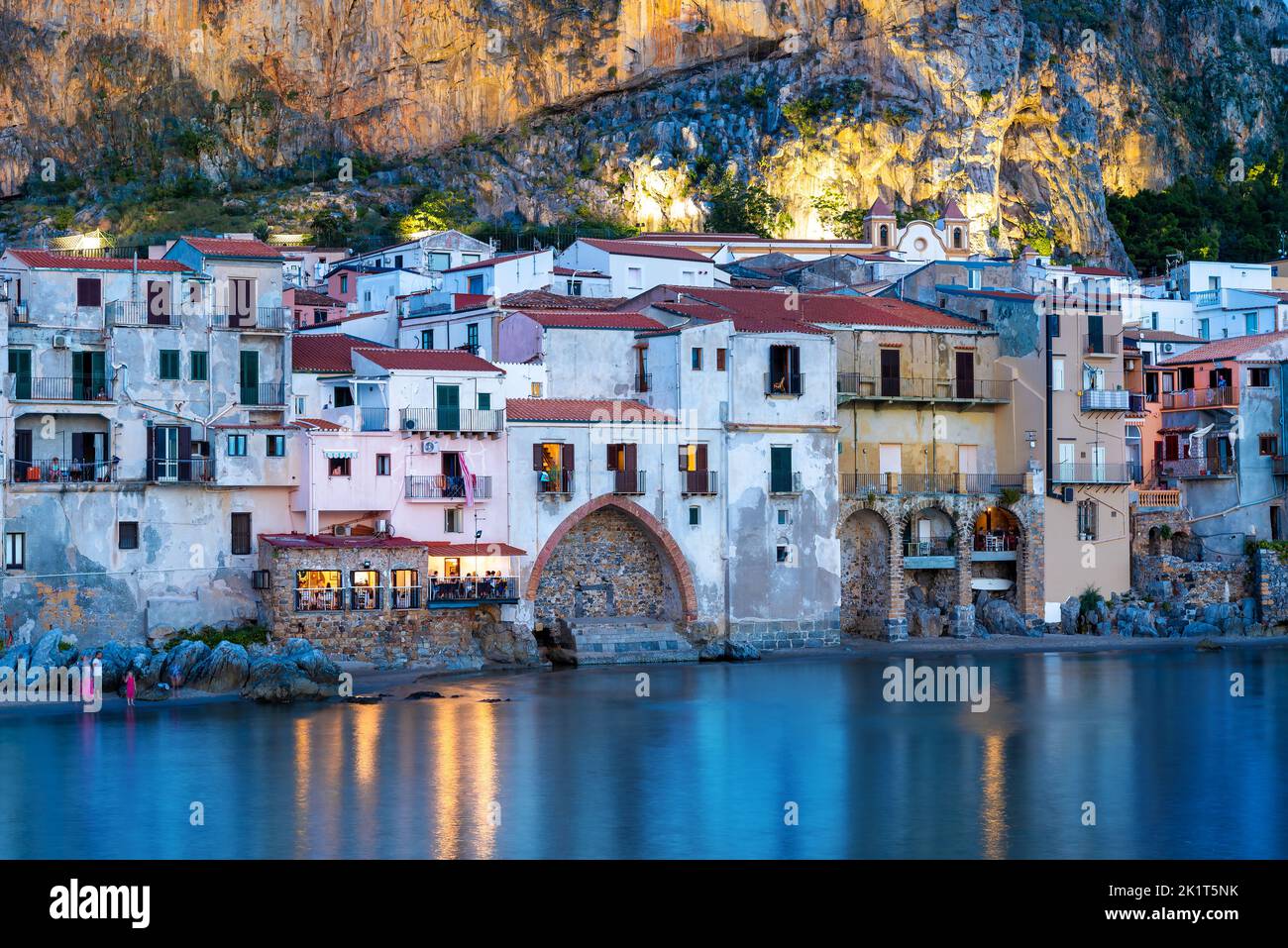 Vista delle case tradizionali architettura illuminata nella luce della sera, vicino alla spiaggia di Cefalù, Isola di Sicilia - Italia Foto Stock