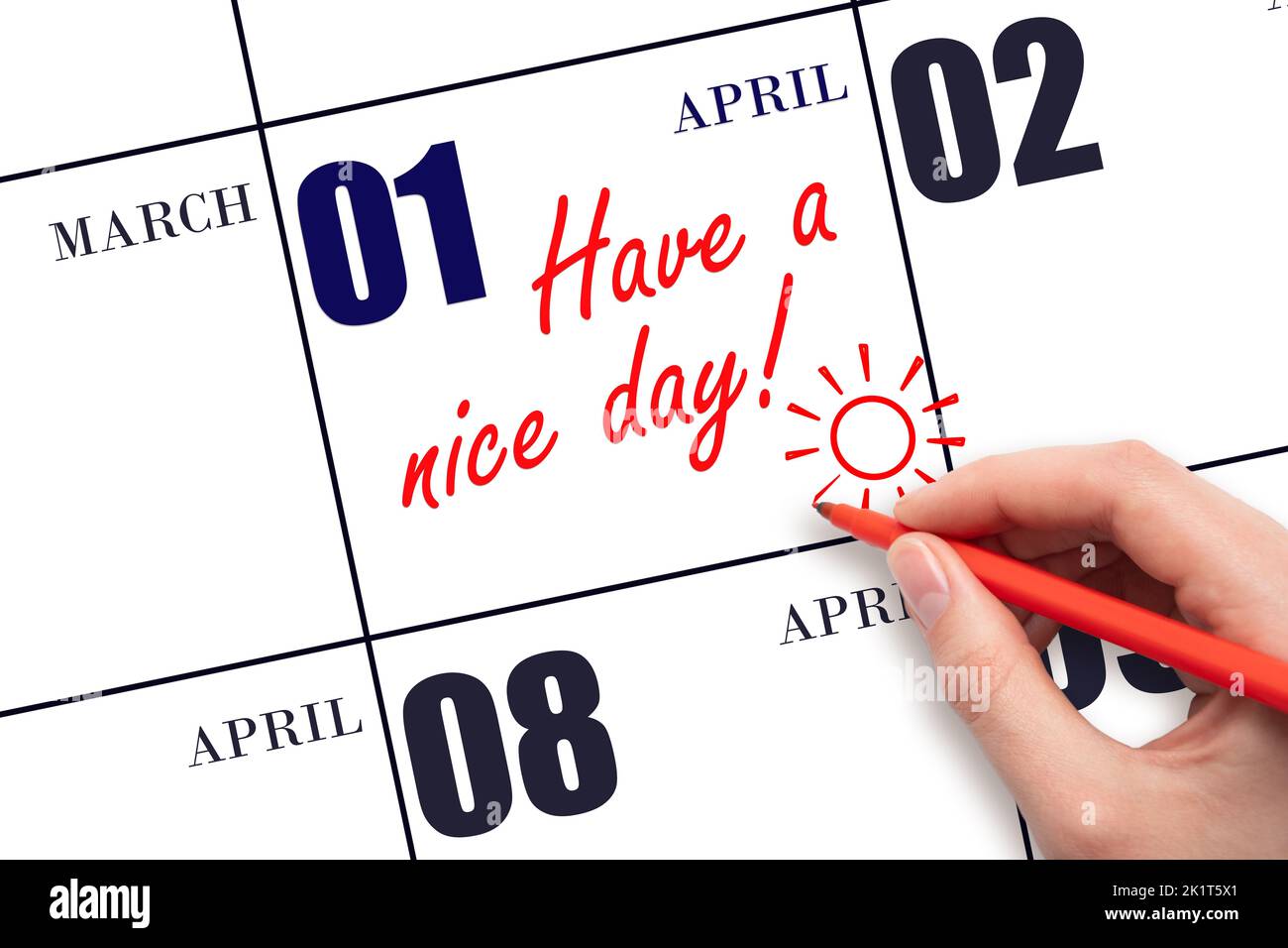 1st° giorno di aprile. La mano che scrive il testo hanno un bel giorno e disegnare il sole sulla data di calendario 1 aprile. Salvare la data. Mese di primavera, giorno del Foto Stock