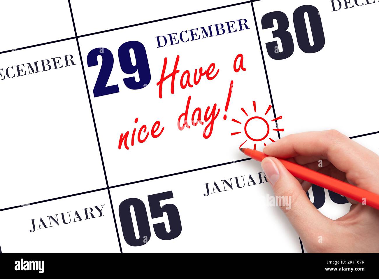 29th° giorno di dicembre. La mano che scrive il testo hanno un bel giorno e disegnare il sole sulla data di calendario 29 dicembre. Salvare la data. Mese invernale, giorno Foto Stock