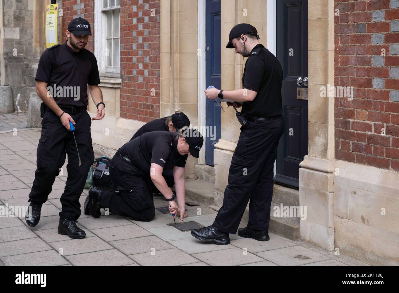 Gli agenti di polizia controllano le botole in una strada vicino al Castello di Windsor davanti al funerale della Regina Elisabetta per operazioni di sicurezza massicce Foto Stock